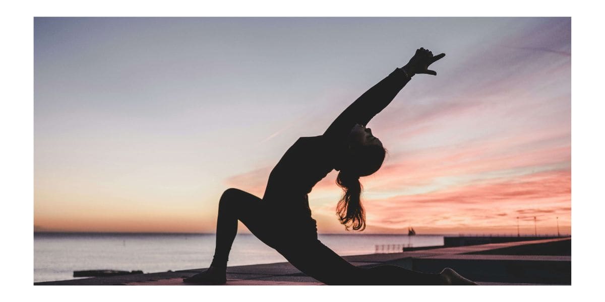 Frau in Yoga-Pose bei Sonnenuntergang am Meer – Symbol für Balance und natürliche Gesundheit